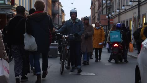 Close-slomo-of-family-with-bikes-on-busy-street-in-fall-in-Stockholm