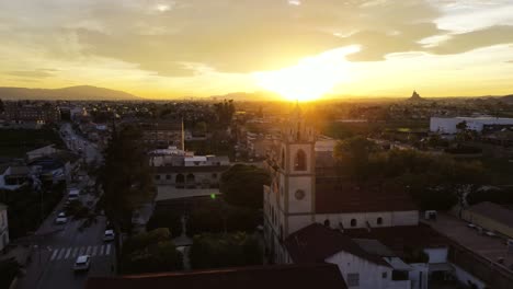 Aerial-drone-view-of-church-bell-tower-or-steeple-against-sunset