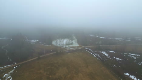 Early-morning-fog-rural-village-nature-landscape-snow-winter-aerial