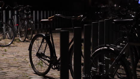 Angebundene-Fahrräder-In-Der-Innenstadt-Von-Kopenhagen,-Dänemark-Bei-Nacht,-Nahaufnahme,-Detail