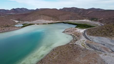 Baja-california's-playa-balandra,-turquoise-waters-embracing-curvy-shores,-desert-landscape,-aerial-view