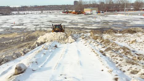 Tractor-correctly-storing-snow-from-large-blizzard-in-Montreal,-Quebec,-Canada