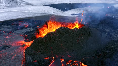 Imágenes-Aéreas-Capturadas-Por-Un-Dron-Cinematográfico-De-4k-Muestran-Un-Volcán-En-Erupción-En-Islandia,-Con-Lava-Que-Fluye-Rápidamente-Y-Un-Fondo-Invernal.