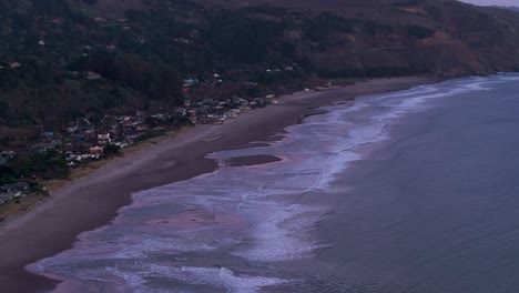 Panning-to-the-right-drone-shot-of-a-dramatic-sunset-beach-in-California