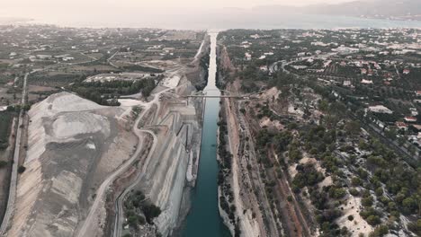 Drone-shot-of-the-natural-wonder-of-the-Isthmus-of-Corinth,-a-narrow-strip-of-land-that-separates-two-bodies-of-water-in-Greece,-connecting-the-Peloponnese-peninsula-to-the-mainland-of-Greece
