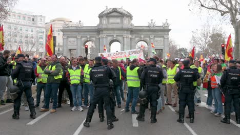 Polizisten-Stehen-Wache,-Als-Sich-Spanische-Landwirte-Und-Agrargewerkschaften-Auf-Der-Plaza-De-La-Independencia-Versammeln,-Um-Gegen-Unlauteren-Wettbewerb,-Agrar--Und-Regierungspolitik-Zu-Protestieren