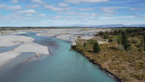 Luftaufnahme-Des-Flusses-Flussabwärts-über-Dem-Wunderschönen-Türkisfarbenen-Waimakariri-Fluss,-Während-Sich-Der-Hauptkanal-Erweitert