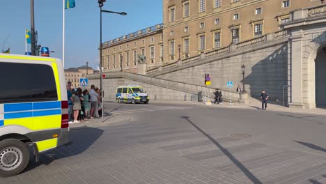 Police-cars-and-Swedish-flags-by-Royal-Palace-on-national-day,-Sweden