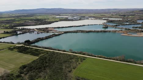 Panoramic-aerial-overview-of-farmland-fields-bordering-ancient-Antela-lagoon-Areeiras-da-Limia-in-Xinzo-de-Limia-Ourense-Galicia-Spain