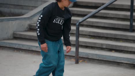 Ein-Junger-Mann-Vermeidet-Vor-Einer-Menge-Jugendlicher-Zuschauer-Unfälle,-Nachdem-Er-Mit-Seinem-Skateboard-Ein-Betongeländer-In-Einem-Skatepark-Hinuntergefahren-Ist