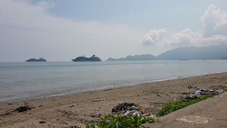 Vista-Al-Mar-Y-A-La-Playa-De-Dos-Cruceros-Amarrados-Cerca-Del-Punto-De-Referencia-Turístico-De-La-Estatua-De-Cristo-Rei-Jesús-En-La-Ciudad-Capital-De-Timor-Oriental,-Sudeste-Asiático