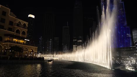 Fuente-En-El-Centro-De-Dubai-Por-La-Noche,-Rociando-Agua-Y-Luces-En-Burj-Khalifa