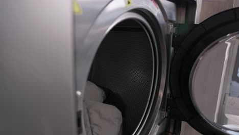 Wäscherei-Mitarbeiter-Lädt-Wäsche-In-Eine-Industriewaschmaschine