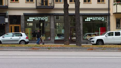 Street-traffic-in-front-of-Smeg-appliance-store-in-Stockholm,-Sweden