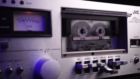 TDK-Audio-Cassette-Tape-Rolling-in-Vintage-JVC-Deck-Player-With-VU-Meters,-Close-Up