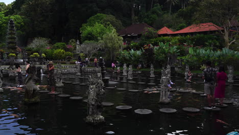 People-in-Pool-of-Tirta-Gangga-Royal-Palace-Gardens,-Bali-Island,-Indonesia