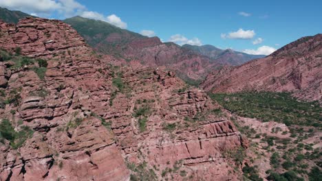 Aerial-rises-over-shattered-red-sandstone-cliffs-in-Guachipa-Argentina