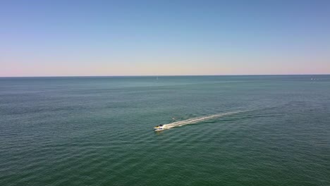 Kamerafahrt-Von-Kleinem-Motorboot-Und-Wakeboarder-Auf-Ruhiger-See