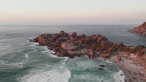 Waves-Crashing-On-Granite-Boulders-At-Sunset-In-Llandudno-Beach,-Cape-Town,-South-Africa