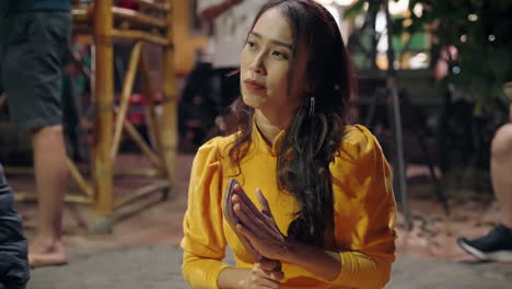 Attractive-Vietnamese-woman-claps-hands-while-watching-Bai-Choi-game-in-Hoi-An,-Vietnam