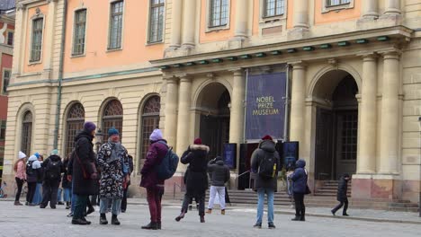 Tourists-outside-Nobel-Prize-Museum-in-winter-in-Stockholm,-Sweden