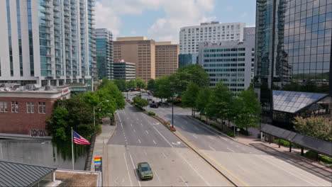 American-Flag-with-driving-cars-in-downtown-of-Buckhead,-Atlanta