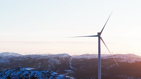 Wind-Turbine-In-Snowy-Mountains-In-Bessaker,-Norway---Drone-Shot