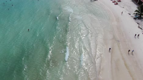 Drone-aerial-view-in-Vietnam-flying-over-Phu-Quoc-island-Sao-beach,-top-view-white-sand,-crystal-clear-blue-turquoise-water,-palm-trees-and-people-walking-and-swimming-on-a-sunny-day