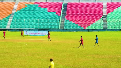 Fußballspieler-Auf-Einem-Lebendigen-Feld-Mit-Stadionsitzen-In-Herzform-Angeordnet,-Sonniger-Tag