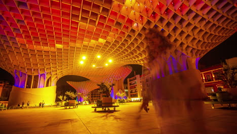Setas-De-Sevilla-Im-Zeitraffer-Unter-Architektonischer-Gestaltung-Mit-Farbenfroher-Beleuchtung,-Während-Touristen-Umherwandern