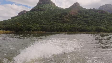 Boats-wake-on-Blyde-River-Canyon-leaves-behind-scenic-African-mountain-landscape