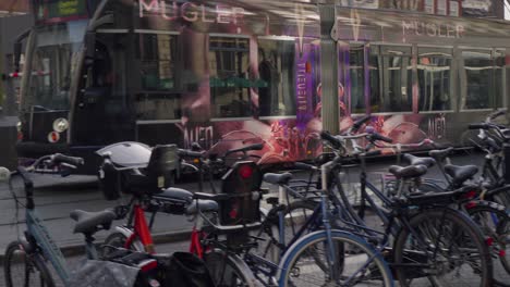 Tilt-up-establishing-shot-of-the-quaint-city-of-Amsterdam-with-tram-riding,-bicycles-parked,-and-facade-of-olden-buildings