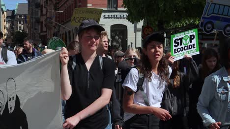 Jóvenes-Marchan-Con-Carteles-En-Una-Manifestación-De-Protesta-Climática,-Primer-Plano-Slomo