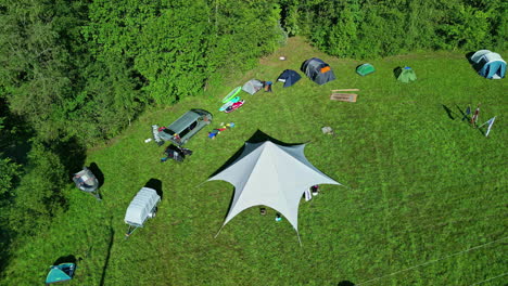 Camping-spot-in-nature-tent-and-car-campervan-beautiful-lake-forest-aerial