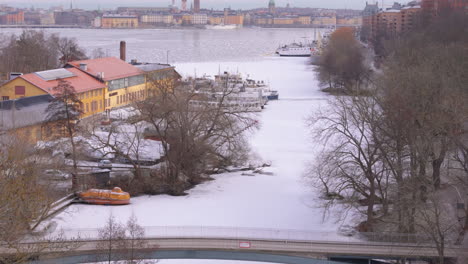 Aerial-dolly-reveal-next-to-Langholmen-and-over-Palsundsbron,-view-of-Gamla-Stan