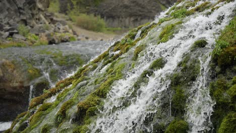 Close-up-of-beautiful-streams-of-small-waterfalls-run-into-a-crystal-clear-and-clean-river