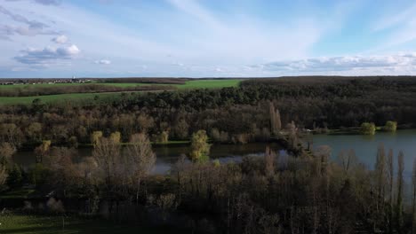 Dampiere-sur-Avre-pond-and-surrounding-rural-landscape,-France