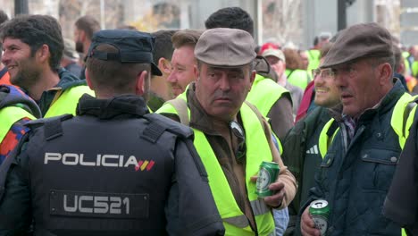 Un-Manifestante-Campesino-Español-Discute-Con-Agentes-De-Policía-Mientras-Agricultores-Y-Sindicatos-Agrícolas-Se-Reúnen-Para-Protestar-Contra-La-Competencia-Desleal,-Las-Políticas-Agrícolas-Y-Las-Políticas-Gubernamentales.