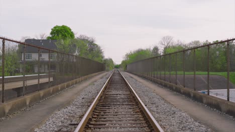 Moving-backwards-view-of-rail-road-tracks-leading-lines