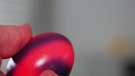 Person-hitting-two-colorful-painted-Easter-eggs-against-each-other,-close-up-slow-motion