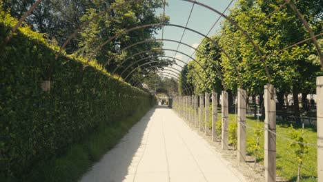 Jardines-Del-Castillo-De-Mirabell-En-Salzburgo,-Con-Estatuas,-Setos-Bien-Cuidados-Y-Turistas-Disfrutando-Del-Paisaje-En-Un-Día-Soleado