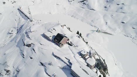 Aerial-of-a-house-surrounded-by-snow-and-mountains