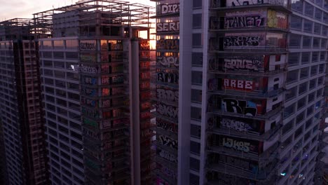 Toma-Panorámica-Aérea-De-Retroceso-Inverso-De-Las-Torres-De-Graffiti-Abandonadas-De-Oceanwide-Plaza-Al-Atardecer-En-El-Centro-De-Los-Ángeles,-California