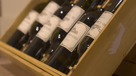 Close-up-of-six-red-wine-bottles-in-wooden-box,-dolly-in