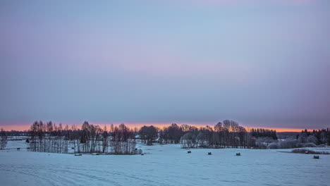 Zeitraffer-über-Verschneite-Winterlandschaft-Mit-Wolkenbedeckung-Während-Des-Morgensonnenaufgangs-Und-Orangefarbenem-Schein