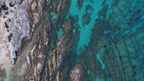 Top-down-close-shot-aerial-view-along-the-famous-Kavourotripes-demonstrating-the-rocky-part-of-the-beach-in-Sithonia,-Chalkidiki,-Greece