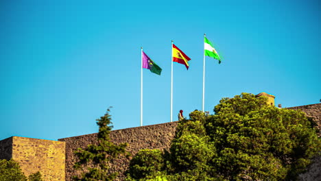 Las-Banderas-De-Andalucia,-España-Y-Málaga-En-El-Lapso-De-Tiempo-Del-Castillo-De-Gibralfaro