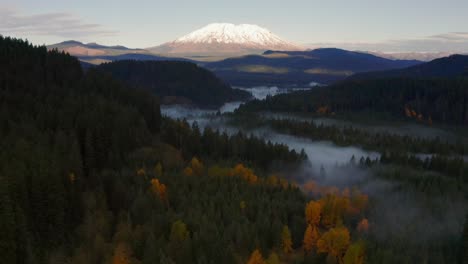 Mystical-Forest-and-Riverscape-Looking-Over-at-the-Snowy-Mount-St-Helens,-Dolly-In-Aerial