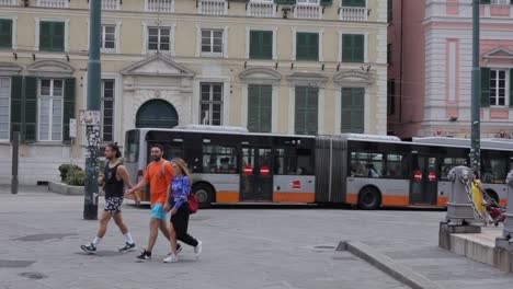 Segmented-bus-driving-over-paved-streets-left-to-right,-in-a-traditional-European-town