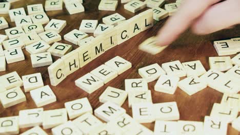 Words-CHEMICAL-and-WEAPONS-made-with-Scrabble-tile-letters,-closeup